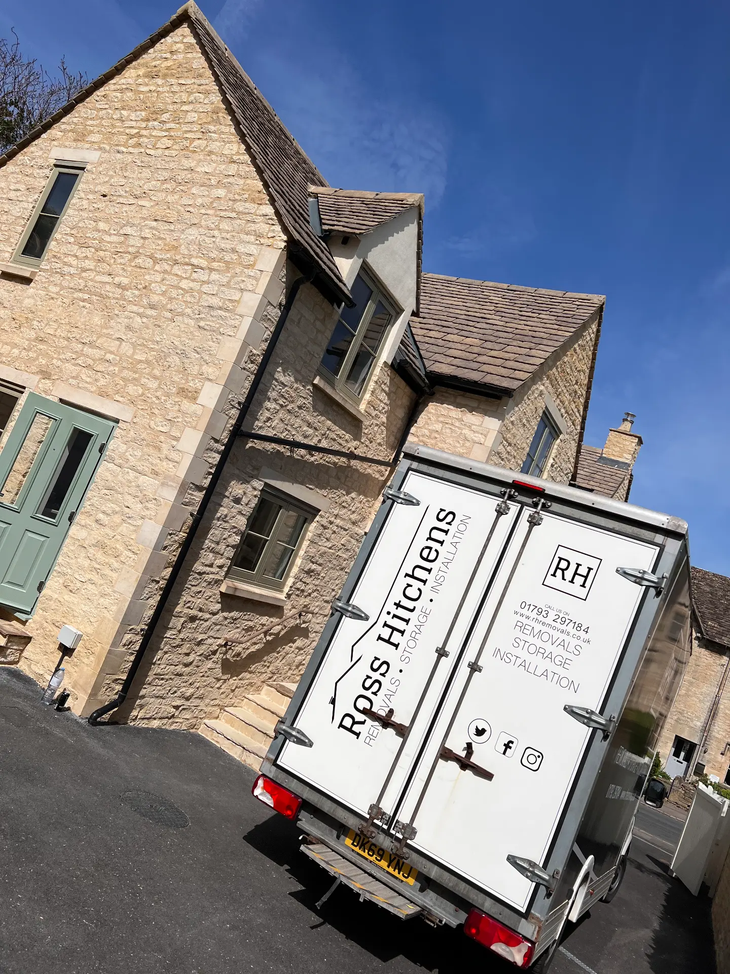 RH removal van outside a Cotswold stone cottage